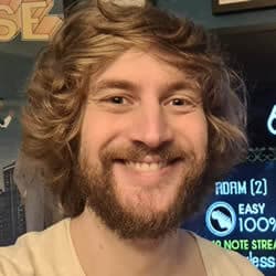 Adam Pacitti with long hair and smiling