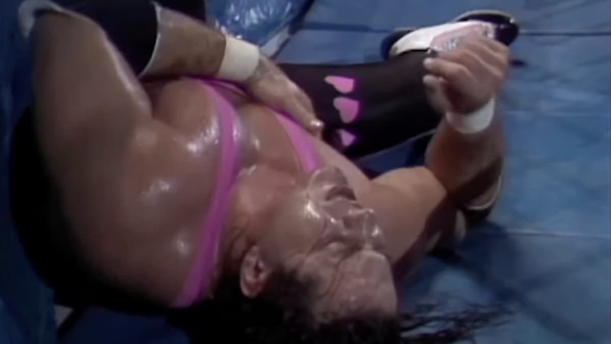 Bret Hart lying down outside of the ring holding his sternum