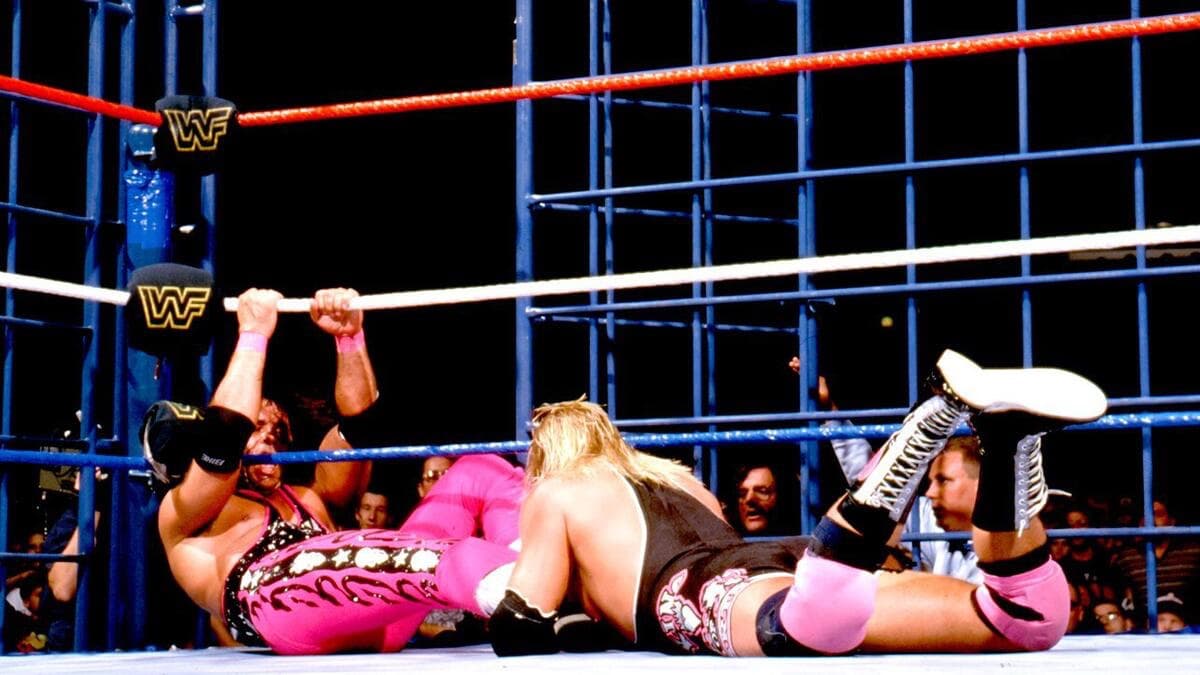 Owen Hart clinging onto Bret Hart as he tried to escape the cage