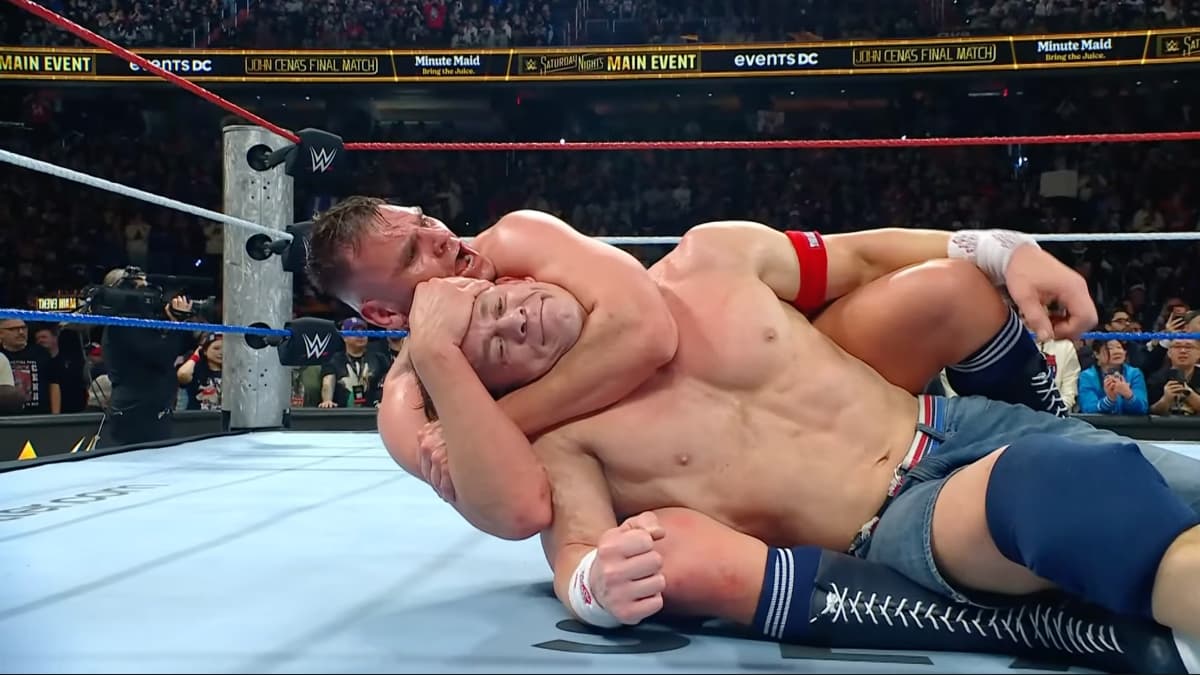 John Cena smiling as he passes out to a choke from Gunther at WWE Saturday Night's Main Event