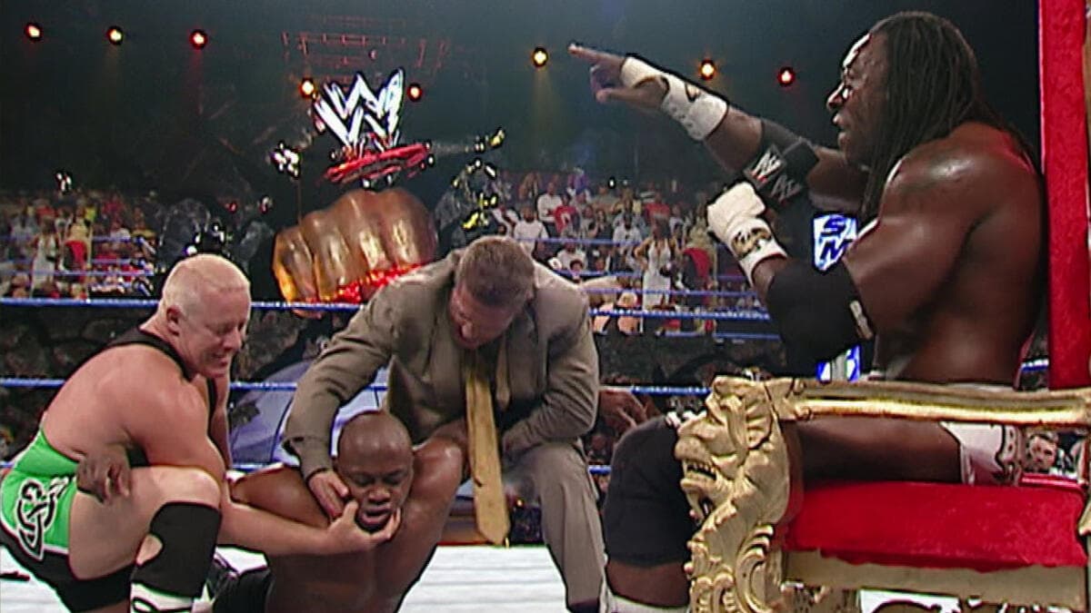 William Regal and Finlay holding down King Booker