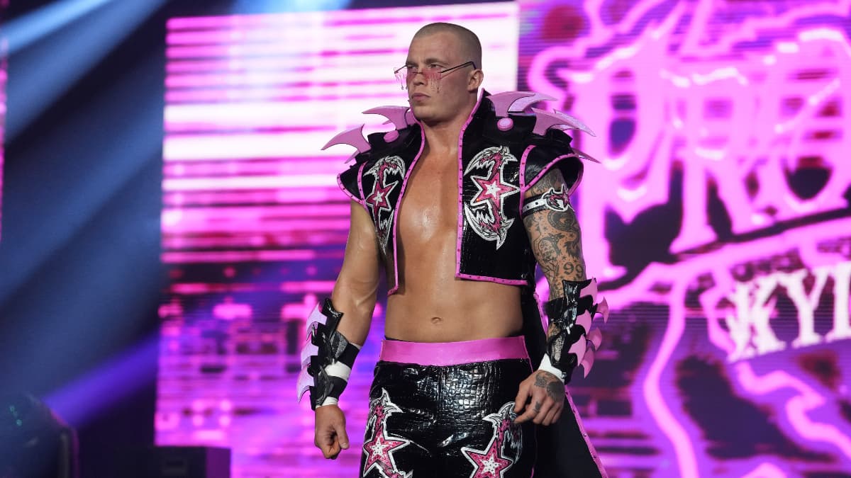 Kyle Fletcher in entrance attire and sunglasses looking pensive 