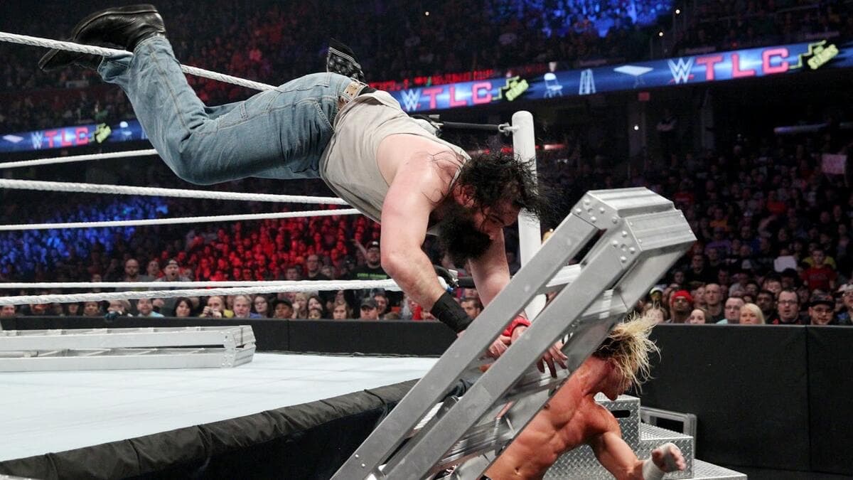 Luke Harper hitting a suicide dive to a ladder as Dolph Ziggler moves out of the way