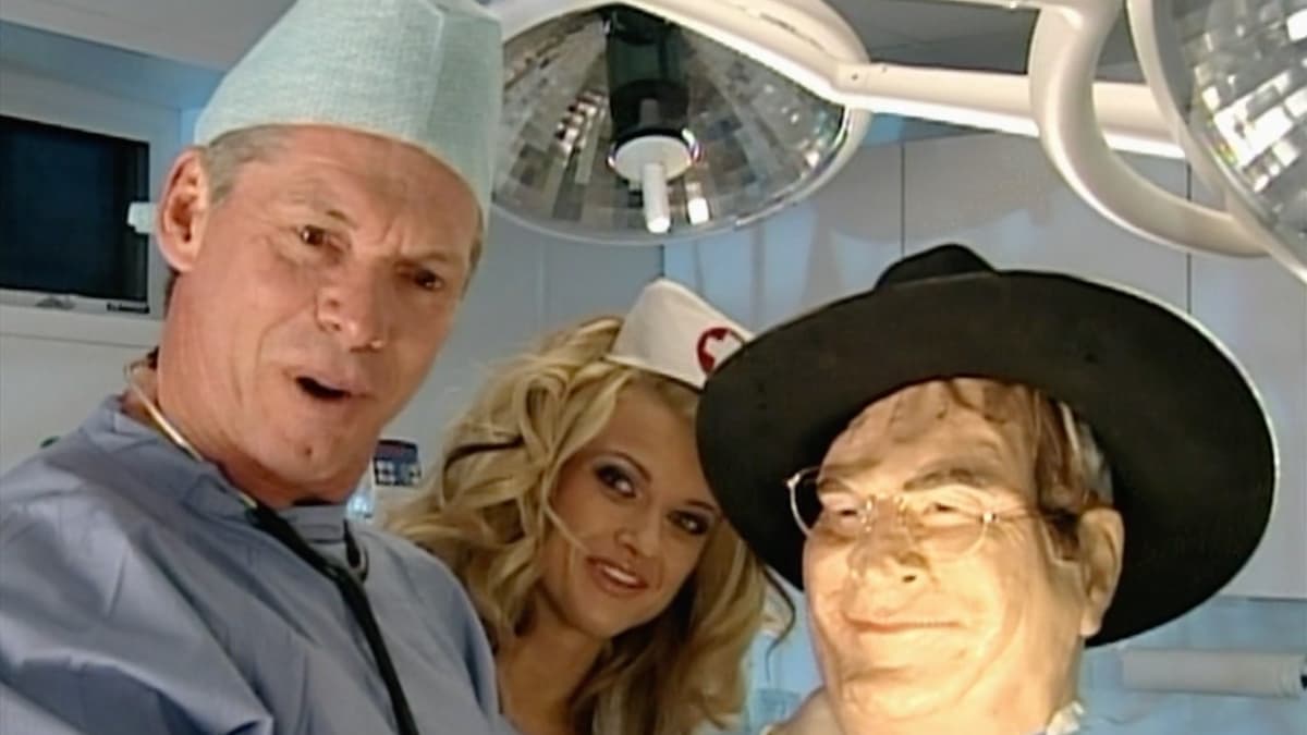 Vince McMaon as Dr. Heiney holding Jim Ross' plastic head in an operating room