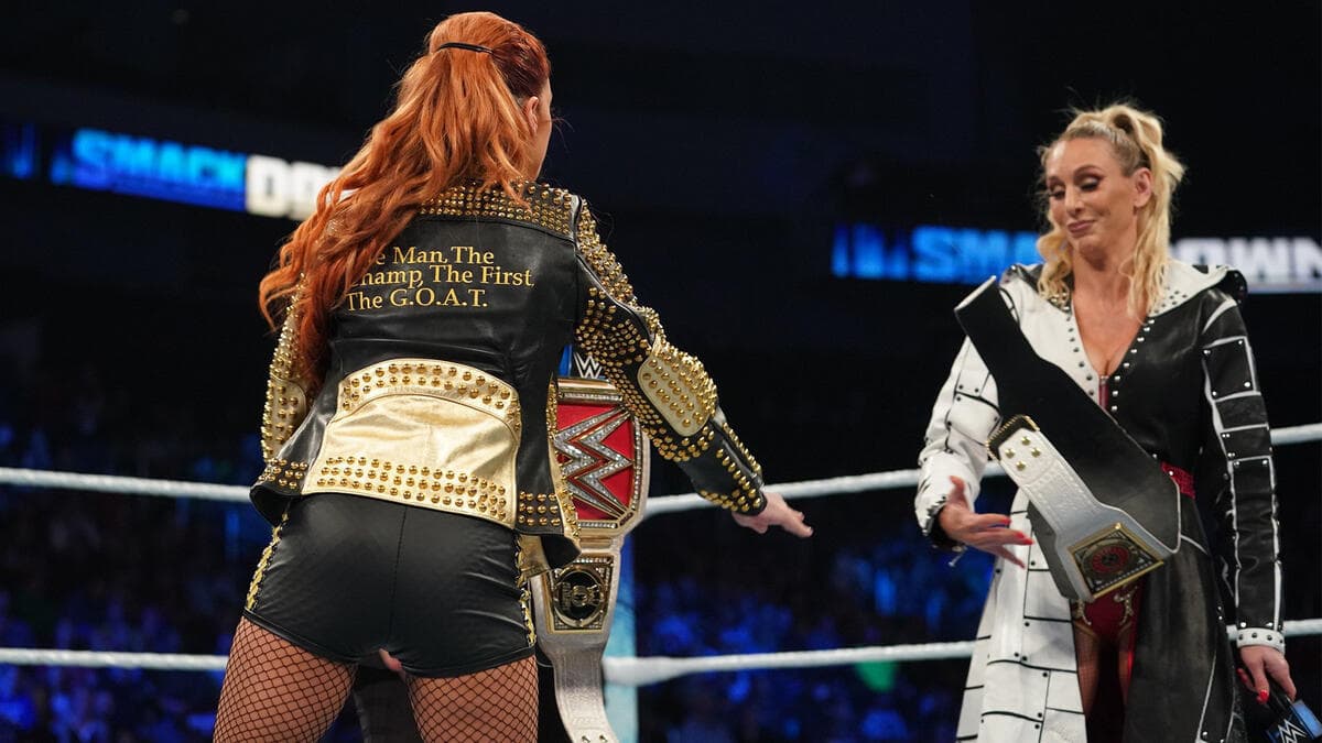 Charlotte Flair throwing the SmackDown Women's Title on the mat as Becky Lynch fails to grab it