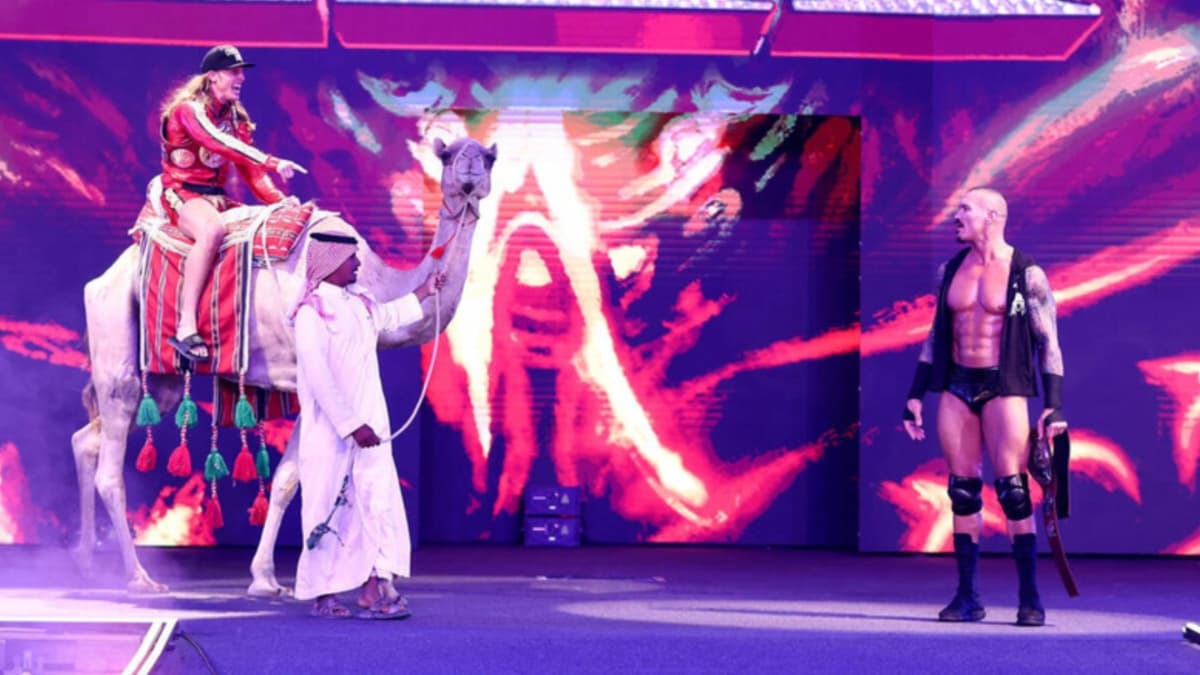 Matt Riddle on a camel on a stage next to Randy Orton