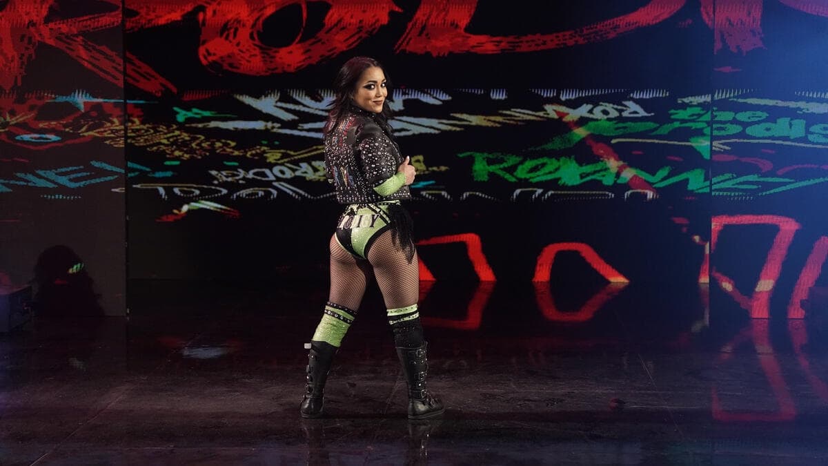 Roxanne Perez turning around during her WWE Raw entrance in green gear and a leather jacket